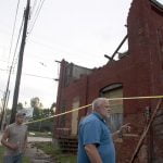 Gary Dunning surveys the damage to his business, after the town was hit by a tornado, in Elmira, New York