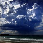 A giant storm cloud can be seen in the sky above swimmers near Mollymook Beach, south of Sydney