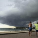 Storm clouds pass over Manly's Fairy Bower on Sydney's north shore as locals look on