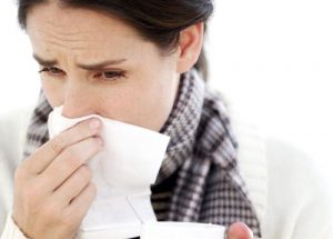 Woman Holding a Mug with a Handkerchief to Her Nose