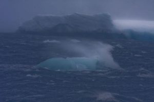 Tempesta con iceberg in movimento lungo la costa dell'Antartide