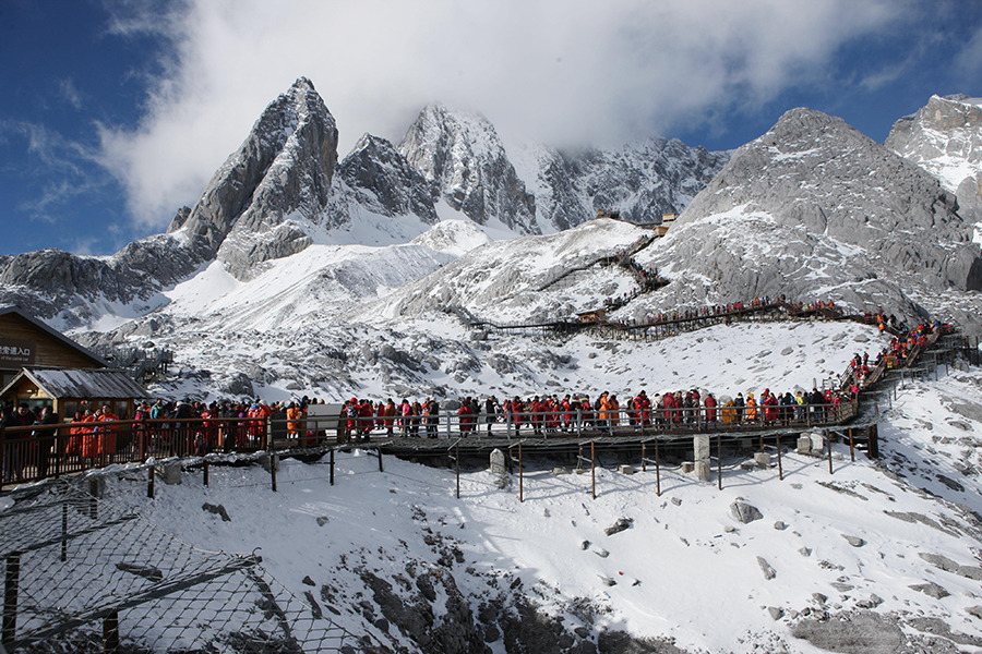 monte innevato Yulong con turisti