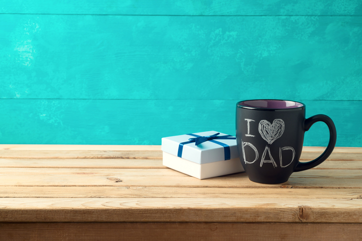 Happy Father’s day concept with coffee mug and gift box over wooden background