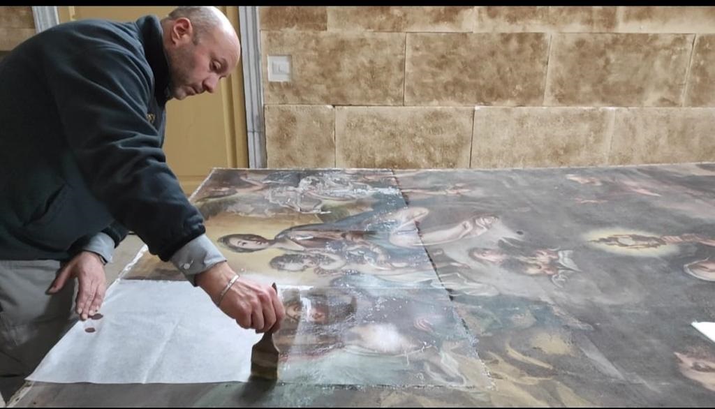 Restauratore al lavoro sul dipinto del convento di Pettineo