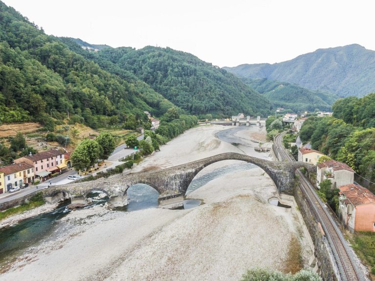 Il ponte della Maddalena sul fiume Serchio in secca, vicino a Lucca, in Toscana. Foto Fabio Muzzi / Ansa