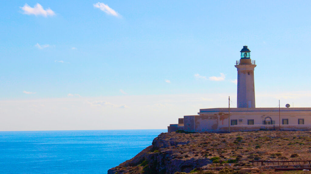 Vista del faro di Capo Grecale dal tetto dell’Osservatorio Atmosferico. A destra del faro si vede l’antenna di ricezione dei segnali trasmessi dalle radiosonde, che permettono di ottenere misure del profilo verticale dei temperatura, pressione, umidità, velocità e direzione del vento. (5/7)