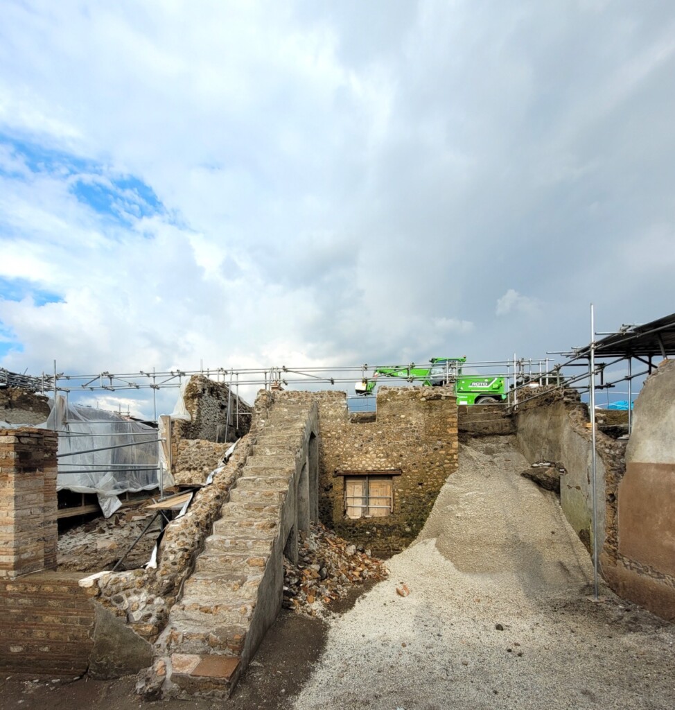 Cumuli di materiale edilizio nel cortile sotto la scala cantiere Regio IX